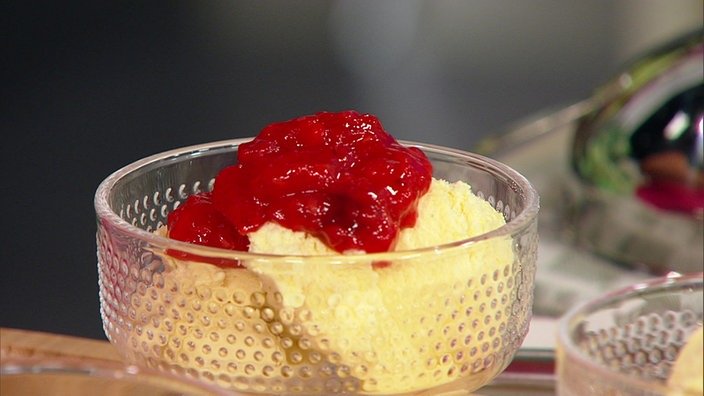 Ein Dessertglas mit Vanilleeis und rotem Kompott