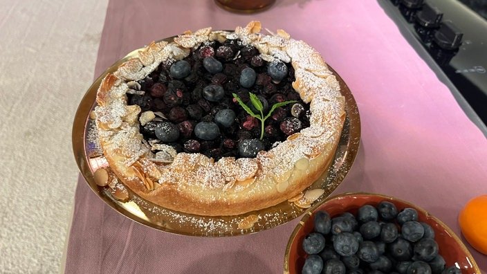 Eine französische Galette mit Blaubeeren auf einer Glasplatte