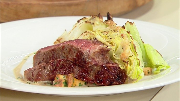 Spitzkohl mit Parmesanhaube und gegrilltes Entrecôte mit Pfifferlingen auf einem Teller