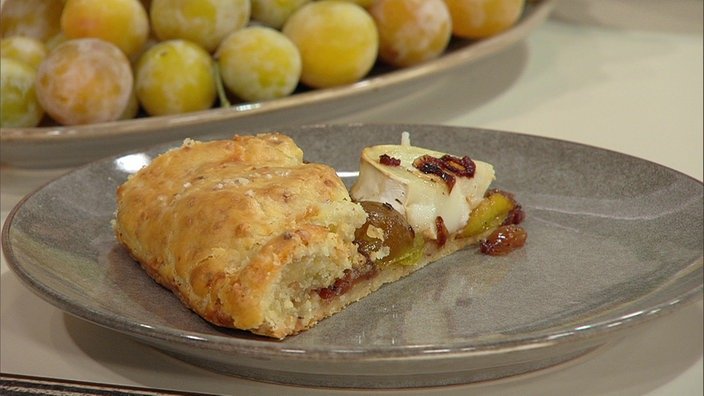 Tarte mit Mirabellen, Ziegenkäse und Haselnüssen auf einem Teller