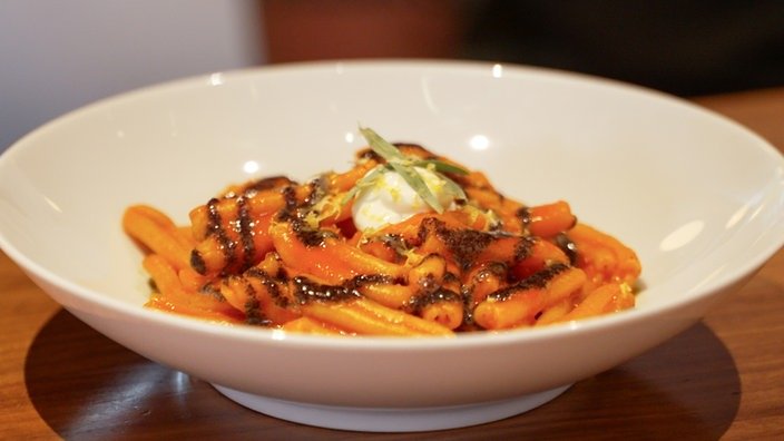 Tiefer Teller mit Pasta mit roter Soße.