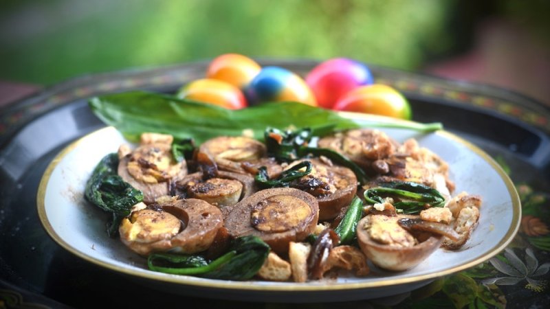 Mehrere Eier in Hälften geschnitten mit Olivenöl, Bärlauch und Sojasauce auf einem Teller.
